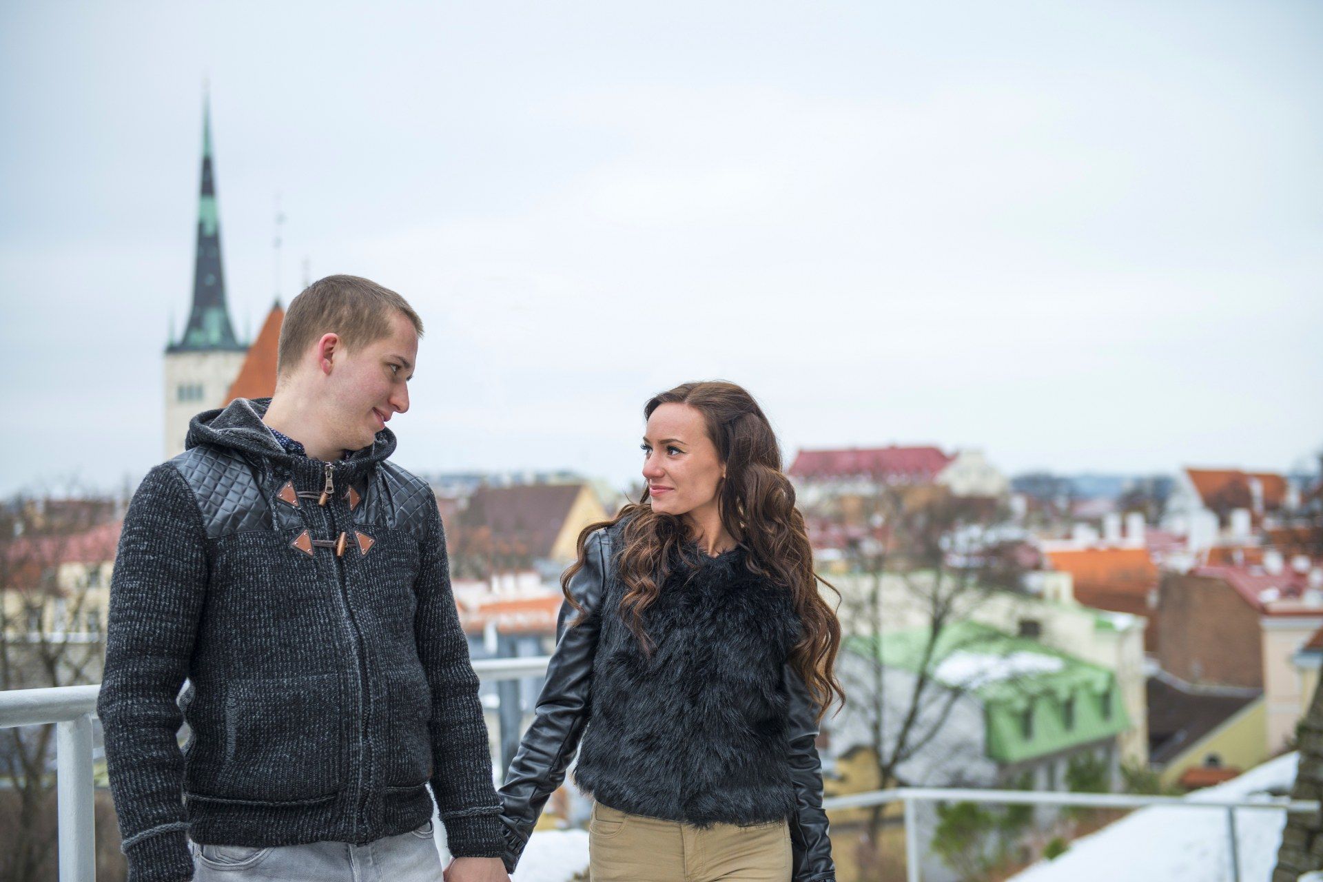Jeune couple main dans la main devant les toits de la vieille ville de Tallinn